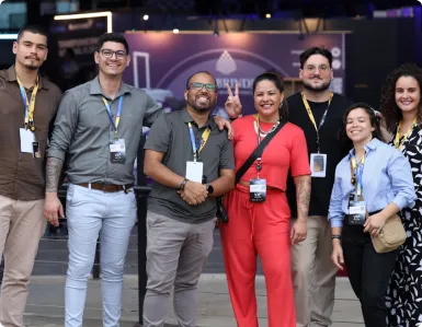 Participantes com crachá posando juntos no Seven Summit 2025